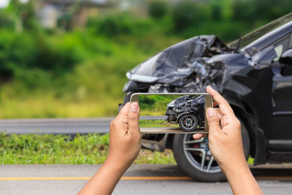 Photo of person taking photo of a car accident