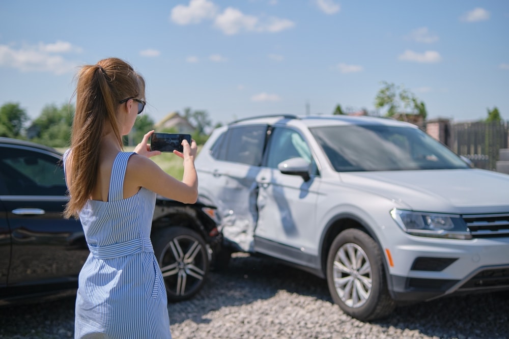 Woman documenting details of car accident